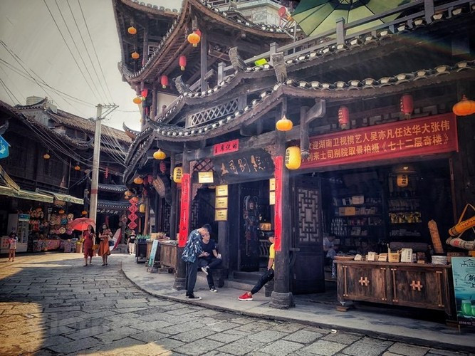 Những ngôi nhà gỗ nằm hai bên thác nước và con đường dài Ngũ Lý được lát bằng những phiến đá xanh mang đậm hơi thở của dân tộc Thổ Gia.