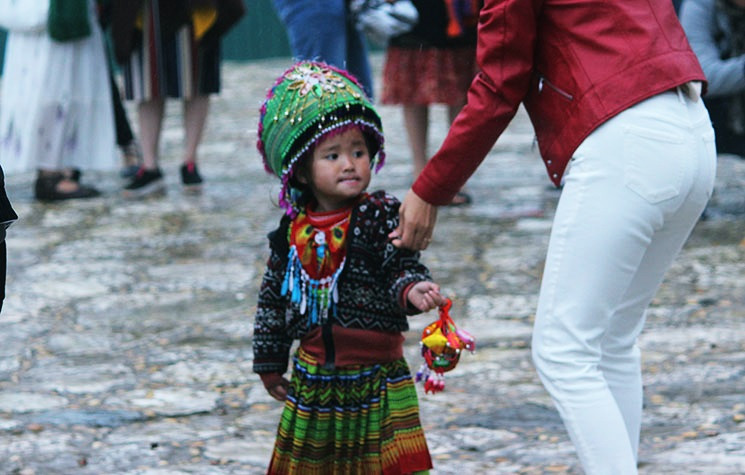 Một bé gái cố đeo bám du khách để nài nỉ mua hàng ở Sa Pa.