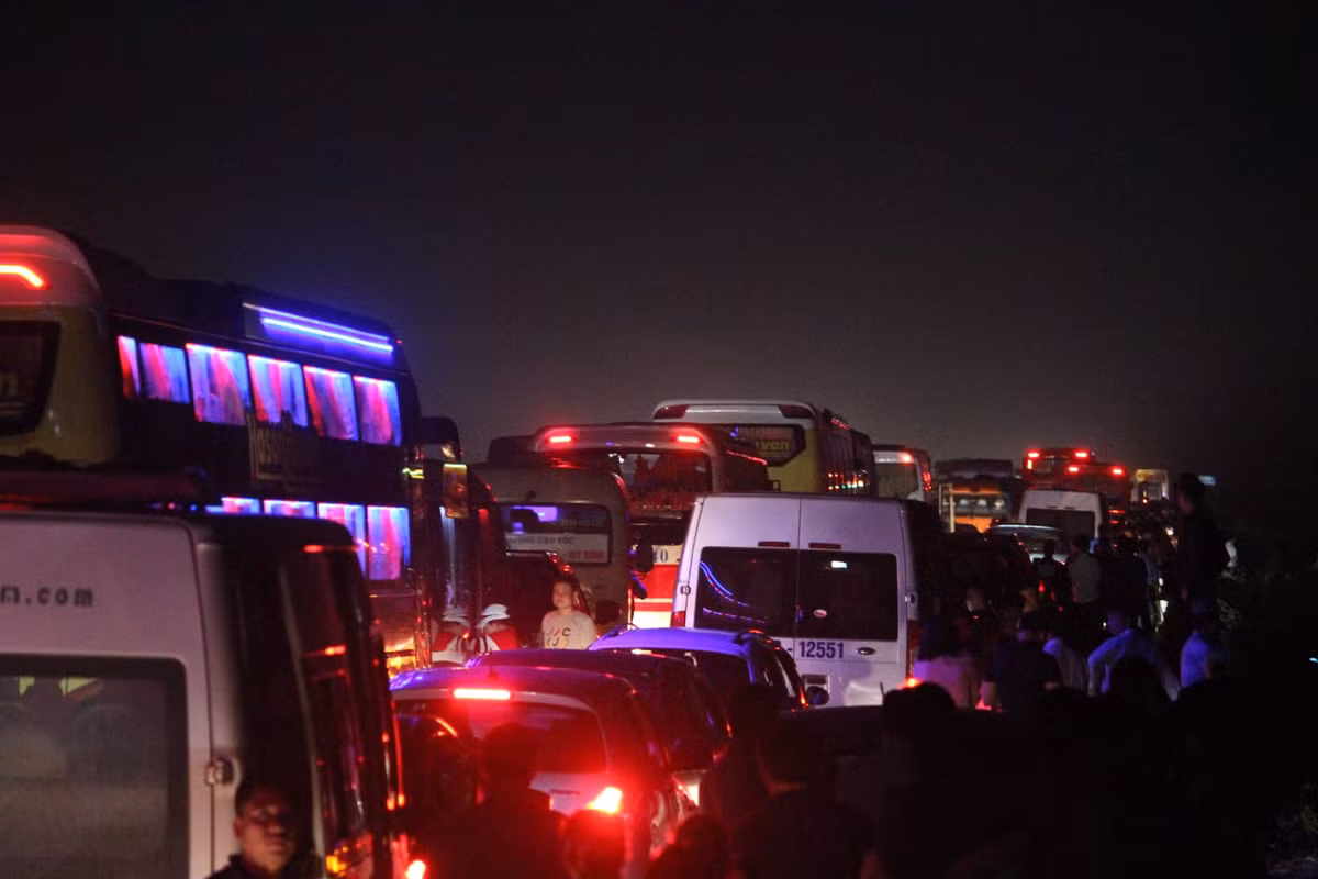 Trong ảnh, nhiều người sốt ruột đã phải rời xe ra đứng bên lề đường cao tốc trong cảnh tắc kinh hoàng.