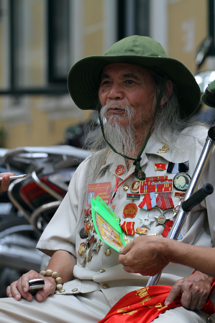 Sau khi viếng nguyên Tổng Bí thư Đỗ Mười xong, ra khỏi Nhà tang lễ Quốc gia được một đoạn do tuổi cao, chân lại đau nên cụ ông Chiến phải ngồi nghỉ nhờ bên chiếc ghế của người dân.