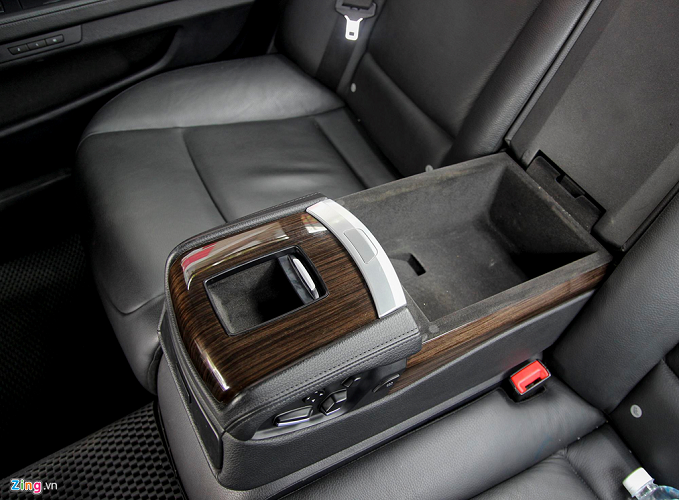 Tiện nghi cho hàng ghế sau khá sơ sài. Xe không có tủ lạnh, chỉ có các hộc chứa đồ đơn giản. Bệ tỳ tay sau cũng được ốp gỗ, màu sắc và độ bóng còn khá tốt.