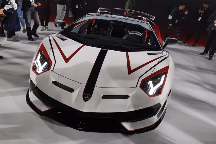 Ở đầu xe, Lamborghini tinh tế tạo nên những chi tiết phỏng theo “mặt nạ” của các diễn viên khi lên sân khấu. Viền đèn được tô đỏ trong khi hai đường kẻ sọc đỏ – đen xuất hiện tạo cảm giác “dữ” hơn.