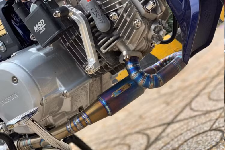 Chiếc xe máy Honda Dream độ với ống trong suốt màu tím dùng làm ống xăng có giá hơn 100 ngàn một tấc đến từ thương hiệu Ariete. Xung quanh lốc máy còn có dàn ốc Inox đầu Salaya khá đẹp.