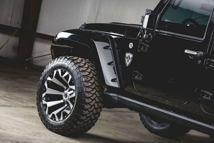 Thiết kế cạnh bên của Jeep Wrangler địa hình này cũng thực sự nổi bật với bộ mâm 22 inch, cỡ lốp 37 inch, vòm che bánh xe Bushwacker, cửa lên xuống DV8 điều khiển bằng điện, tay nắm cửa chế tạo riêng.