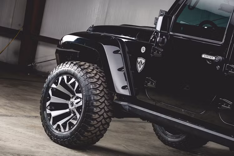 Thiết kế cạnh bên của Jeep Wrangler địa hình này cũng thực sự nổi bật với bộ mâm 22 inch, cỡ lốp 37 inch, vòm che bánh xe Bushwacker, cửa lên xuống DV8 điều khiển bằng điện, tay nắm cửa chế tạo riêng.