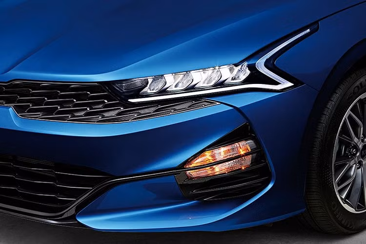 Về thiết kế, K5 sở hữu một tổng thể thể thao “không chê vào đâu được” và là thành quả phát triển của các studio tại Bắc Mỹ, châu Âu và Hàn Quốc. Mặt trước của xe nổi bật với cụm lưới tản nhiệt hình mũi hổ đặc trưng, kéo dài và ôm trọn bề ngang. Cụm đèn LED của K5 2021 nay càng thêm sắc sảo với dải định vị ban ngày hình biểu đồ ‘nhịp tim’.