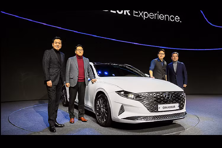 Điểm duy nhất không thay đổi có lẽ là dáng hất lên của đuôi xe. Ngoài ra, dòng chữ G R A N D E U R chạy ngang nắp cốp cũng giống như bản cũ. Dù chỉ là bản facelift nhưng Grandeur mới có trục cơ sở dài hơn 40 mm và rộng hơn 10 mm. Tổng thể chiếc xe bây giờ là dài x rộng x cao tương ứng 4.990 x 2.885 x 1.875 mm. Điều này hứa hẹn cho một không gian cabin rộng rãi hơn trước.