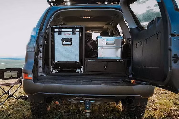 Sẵn sàng cho mọi tình huống khó khăn, GX Off-Road còn có một cặp thùng nhôm chứa các dụng cụ quan trọng cùng tấm cầu tăng ma sát Maxtrax để sẵn trên baga. Khu vực trống còn lại là nơi lắp đặt các tấm pin năng lượng mặt trời Overland 160W.