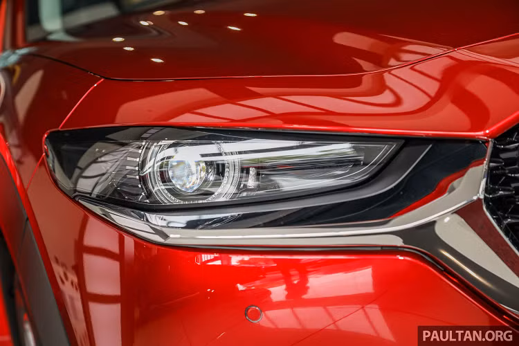 Mazda CX-30 phiên bản 2.0 High cao cấp được trang bị đèn pha LED có chức năng tự động cân bằng (tiêu chuẩn cho tất cả các CX-30), đèn LED chiếu sáng ban ngày, chìa khóa thông minh (Keyless Entry), khởi động bằng nút bấm (Start/Stop). Tổng thể hài hoà với “dàn chân” lắp mâm 18 inch (215/55R18).