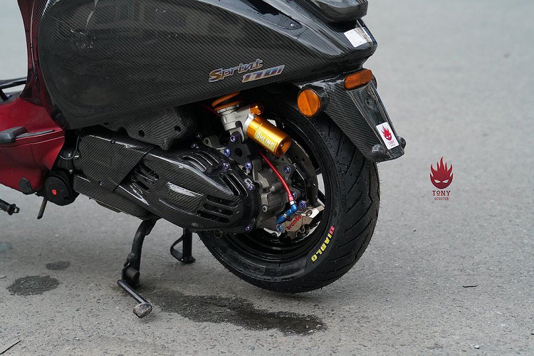 Sau thân xe, điểm nhấn độc đáo thứ 2 của bản độ Sprint này đó là phần đầu với tay lái gập cụp xuống lấy cảm hứng từ những chiếc xe đua Vespa, nhằm giúp "tay nài" có tư thế ngồi núp gió ít cản không khí hơn. Ở phía trên tay lái cũng là hàng loạt các phụ tùng chuyên dụng. Bảng đồng hồ nguyên bản của Vespa Sprint đã được thay bằng đồng hồ điện tử đa năng của S.I.P, ngoài ra một đồng hồ Koso Mini 3 nhỏ gọn còn được gắn thêm ở trên mào chắn gió.