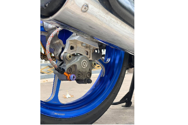 Ở phía sau, chiếc xe Honda Dream độ khủng này đã không chỉ được tăng lên bởi cặp phuộc Ohlins đắt giá, mà còn do trục cơ sở dài hơn một chút do chủ xe đã sử dụng gắp nhôm độ vốn dành cho Honda Wave. Giống như phía trước, hệ thống phanh sau đã được nâng cấp lên phanh đĩa với heo Brembo logo lớn cùng bình dầu AEM.