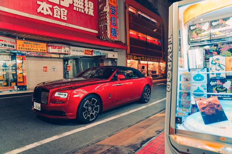 Trong khi đó, nhiếp ảnh gia người Anh - Mark Riccioni - bắt đầu chụp chiếc Dawn Black Badge ở Akihabara, màu sơn đỏ Magma Red rất ăn nhập với các biển hiệu đầy màu sắc xung quanh. Sau đó, Mark Riccioni đã tiếp tục đưa Rolls-Royce Dawn Black Badge ra các hòn đảo của Vịnh Tokyo và các đường phố dân cư Nakameguro khi mặt trời mọc.