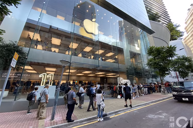 Trong hình, có thể thấy hàng người xếp hàng chờ lấy iPhone đã đặt trước ở bên phải, còn những người chờ mua trực tiếp ở bên trái. Tại các cửa hàng, người đặt trước sẽ được vào lấy máy từ 8h, trong khi người mua trực tiếp sẽ phải chờ tới 10h, thường không còn nhiều lựa chọn về dung lượng hay màu sắc. Ảnh: HK01. 