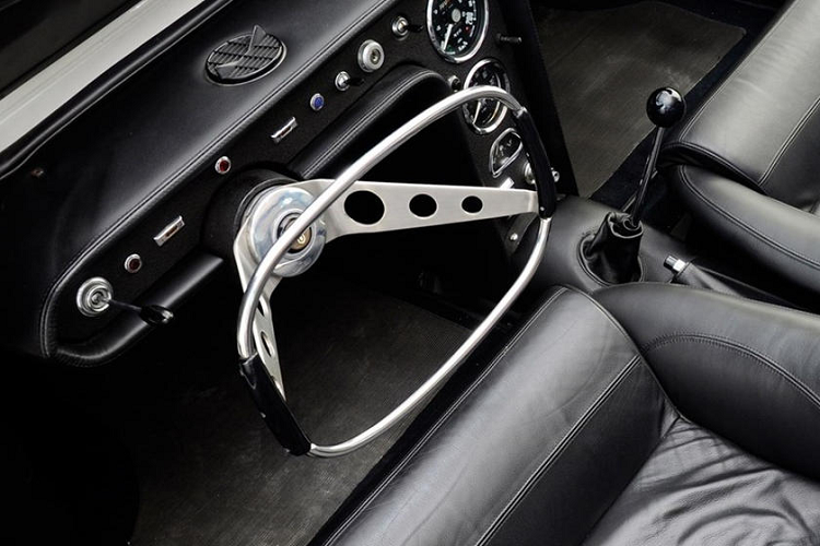 Vô lăng 2 chấu với thanh kim loại dạng mảnh ở giữa.