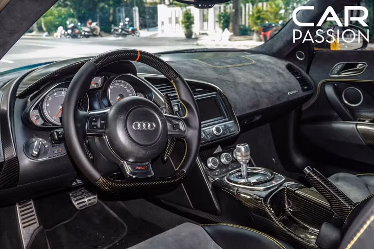 Chủ nhân đã mạnh dạn chi không ít tiền đã làm mới toàn bộ khoang nội thất, ghế ngồi và vô-lăng thuộc phiên bản R8 GT, vô-lăng và cần số phía sau được làm hoàn toàn từ sợi carbon, bảng táp-lô, nóc xe và ghế ngồi được bọc da alcantara thể thao với điểm nhấn là các đường chỉ thêu màu vàng tương tự như ngoại thất của xe.