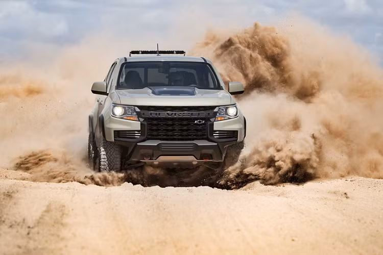 Lưới tản nhiệt với cản trước hầm hố, cụm đèn pha sắc nét và 2 móc kéo màu đỏ ở đầu xe tạo nên vẻ hung hăng cho Colorado. Thân xe có thêm ốp vòm bánh, thanh đòn trang trí thùng tải màu đen, lốp off-road.