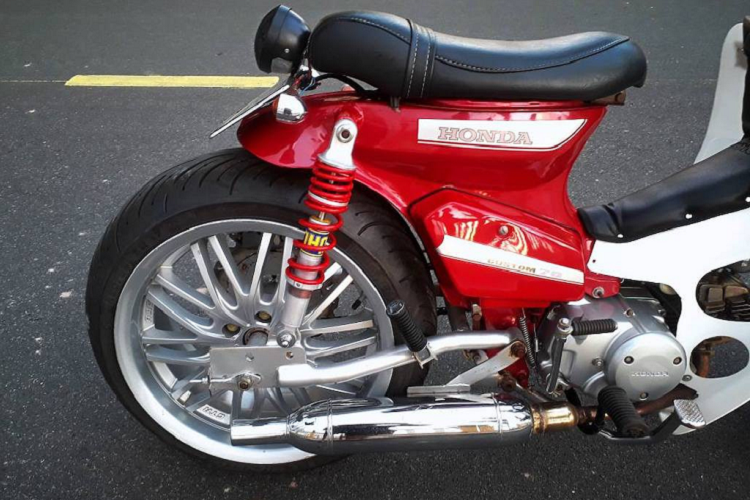 Trong khi đó, bánh sau có bộ gắp hoàn toàn mới, được gia công từ thép ống. Các tai bắt phuộc trên khung cũng đã được nới rộng. Ngay cả những chiếc mâm cũng đã phải được chủ xe tiện moay-ơ riêng để lắp được bánh lớn. Cặp moay-ơ này đồng thời là điểm bắt những đĩa phanh, nâng cấp hệ thống phanh đùm lên thành phanh đĩa an toàn hơn.