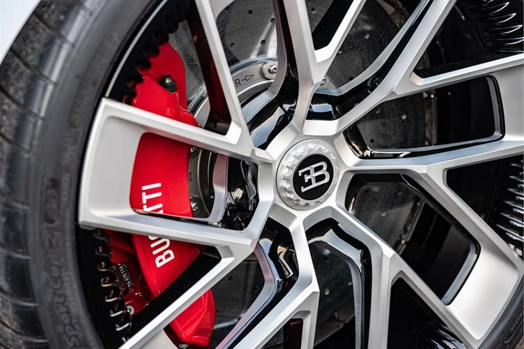 Bên sườn của Bugatti Centodieci xuất hiện bộ vành hợp kim sơn màu trắng phối đen ấn tượng. Nằm sau bộ vành này là cùm phanh màu đỏ đập vào mắt.