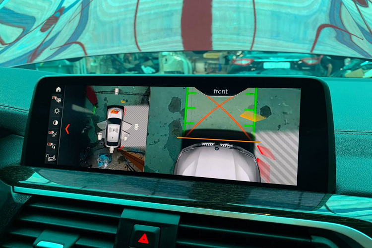 Cần số có logo M. Phía trước vô-lăng còn có màn hình hắt kính HUD. Màn hình chính giữa xe hỗ trợ Apple CarPlay, hiển thị camera 360 độ. Trên X4 chính hãng, xe chỉ có cảm biến xung quanh và camera lùi.