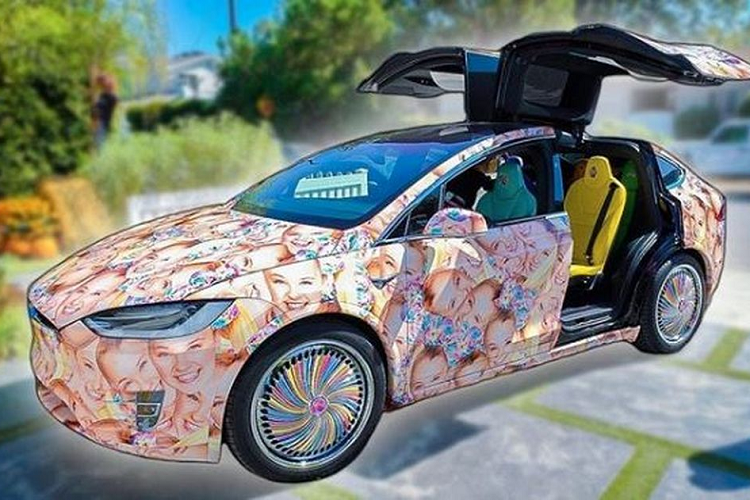 JoJo Siwa với chiếc Tesla Model X tràn ngập hình ảnh khuôn mặt của chính mình. Những người bạn đã gửi tặng JoJo một chiếc Tesla Model X với thiết kế tràn ngập hình ảnh khuôn mặt của cô ấy, bánh xe sơn màu cầu vồng và ghế ngồi với nhiều màu sắc khác nhau. Trái ngược hẳn với thiết kế nguyên bản nhẹ nhàng và lịch sự, chiếc Model X này đã trở nên sặc sỡ tới lố bịch!