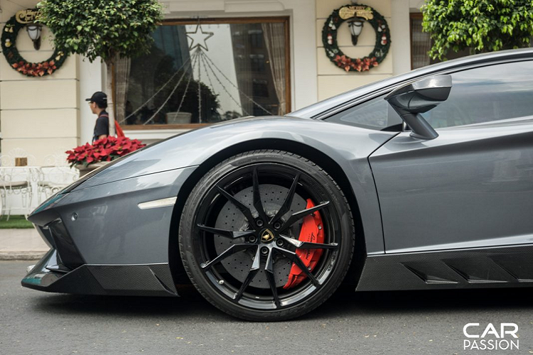 Khác biệt với phần lớn những chiếc Lamborghini Aventador LP700-4 còn lại ở Việt Nam, “siêu bò” này sở hữu bộ mâm đa chấu được sơn đen. Bên trong là hệ thống phanh đĩa hiệu năng cao với cùm phanh sơn đỏ cùng đĩa phanh gốm carbon có khả năng chịu nhiệt lớn nên sẽ bền hơn so với phanh thép thông thường.