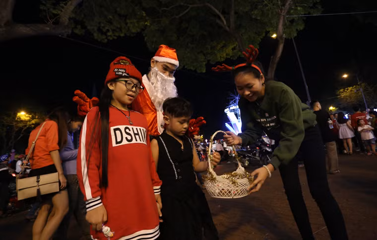 Trẻ em thích thú được phát quà trong đêm Noel.