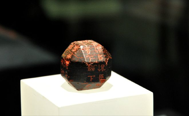 Bề ngoài của cục đá này đen sì nhưng rất sáng, và được khắc chữ màu đỏ.