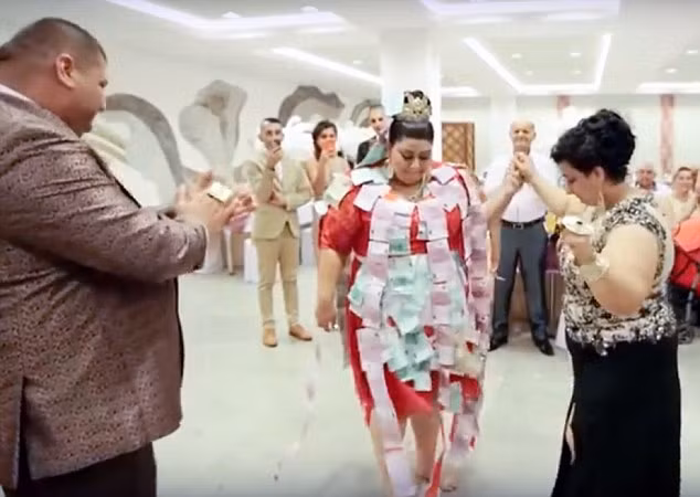 Cô dâu diện chiếc váy đính đầy tiền mặt khiêu vũ.