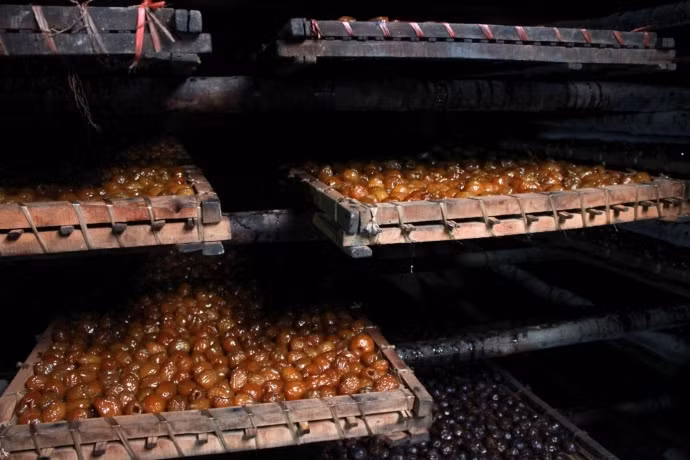 Công đoạn nấu nước đường được lặp lại 3 lần, mỗi lần cách nhau 24h. Ở giai đoạn cuối cùng, táo được vớt ra rồi cho lên giàn (phên), cho vào lò sấy thành mứt thành phẩm. Táo thành phẩm tại làng Vị phải đảm bảo có màu vàng óng vì được sản xuất bằng đường trắng, có nhiều lớp khía ở bên ngoài quả, ăn có độ dẻo và ngọt vừa phải, thịt quả táo dầy, táo không bị quắt, không bị đen. Ảnh: Báo Giao Thông.