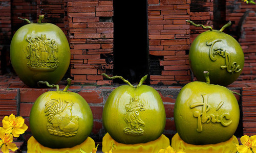 Nếu các năm trước dừa chỉ được in chữ và thiết kế theo hình dáng hồ lô thì Tết Đinh Dậu năm nay xuất hiện một loại dừa với trái to, bóng và khắc họa thêm hình Song Kê (gà), Phúc Lộc Thọ, Quan âm Bồ tát…Để tạo hình trái dừa độc đáo có hình gà, Quan âm Bồ tát, Phúc - Lộc - Thọ…, phải làm ra được những chiếc khuôn chuẩn để ép vào trái dừa trong một thời gian nhất định. Ảnh: Vnexpress.