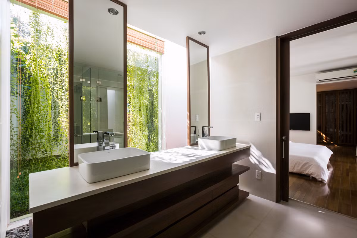 Nhà vệ sinh cũng có tường kính nhìn ra khu vườn tươi xanh.