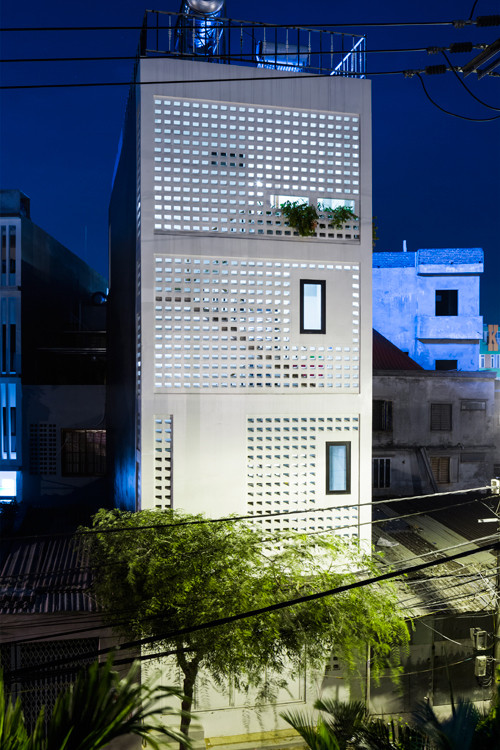 Mặt sau nhà tiếp giáp với đường lớn lại phải nhận nắng hướng Tây, gió Bắc. Bởi vậy, nhóm kiến trúc sư đã đưa ra giải pháp bao che công trình bằng gạch lỗ có cấu tạo ngăn mưa tạt. Giải pháp này đảm bảo công trình bớt nắng gắt, bụi bặm, được chiếu sáng và thông gió tự nhiên.