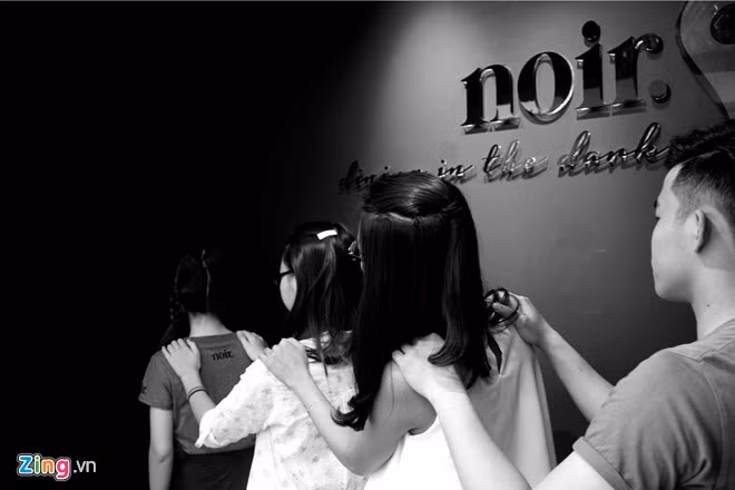 Dining in the dark (Ăn trong bóng đêm) đã có mặt ở rất nhiều quốc gia trên thế giới nhưng đây là lần đầu tiên xuất hiện tại Việt Nam. Ảnh: Nhân viên dẫn khách vào bàn ăn trong bóng tối.