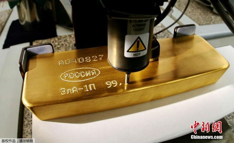 Những thỏi vàng "4 số 9" cùng thông tin về ngày hoàn thành sản phẩm được khắc trên bề mặt. Trong hình là cỗ máy dùng để chạm khắc thông tin lên những thỏi vàng tại nhà máy.