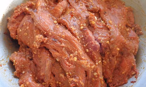 Thịt lợn khi sấy khô thường hao hơn so với thịt trâu và thịt bò, nên khi thái miếng thịt lợn cũng thường to hơn miếng thịt trâu, bò để làm khô. Thông thường, người ta sẽ thái thịt lợn thành từng miếng vuông vắn dài khoảng 20-25cm, rộng 9-10cm, dày 4-5cm rồi tẩm ướp gia vị. Gia vị để làm thịt lợn khô bao gồm muối, ớt, gừng, tỏi, mắc khén, hạt dổi (nếu có) và vài loại lá rừng tùy theo người làm lựa chọn. Tất cả những loại gia vị này đem giã nhuyễn với nhau làm hỗn hợp tẩm ướp thịt lợn. Ảnh: Internet.