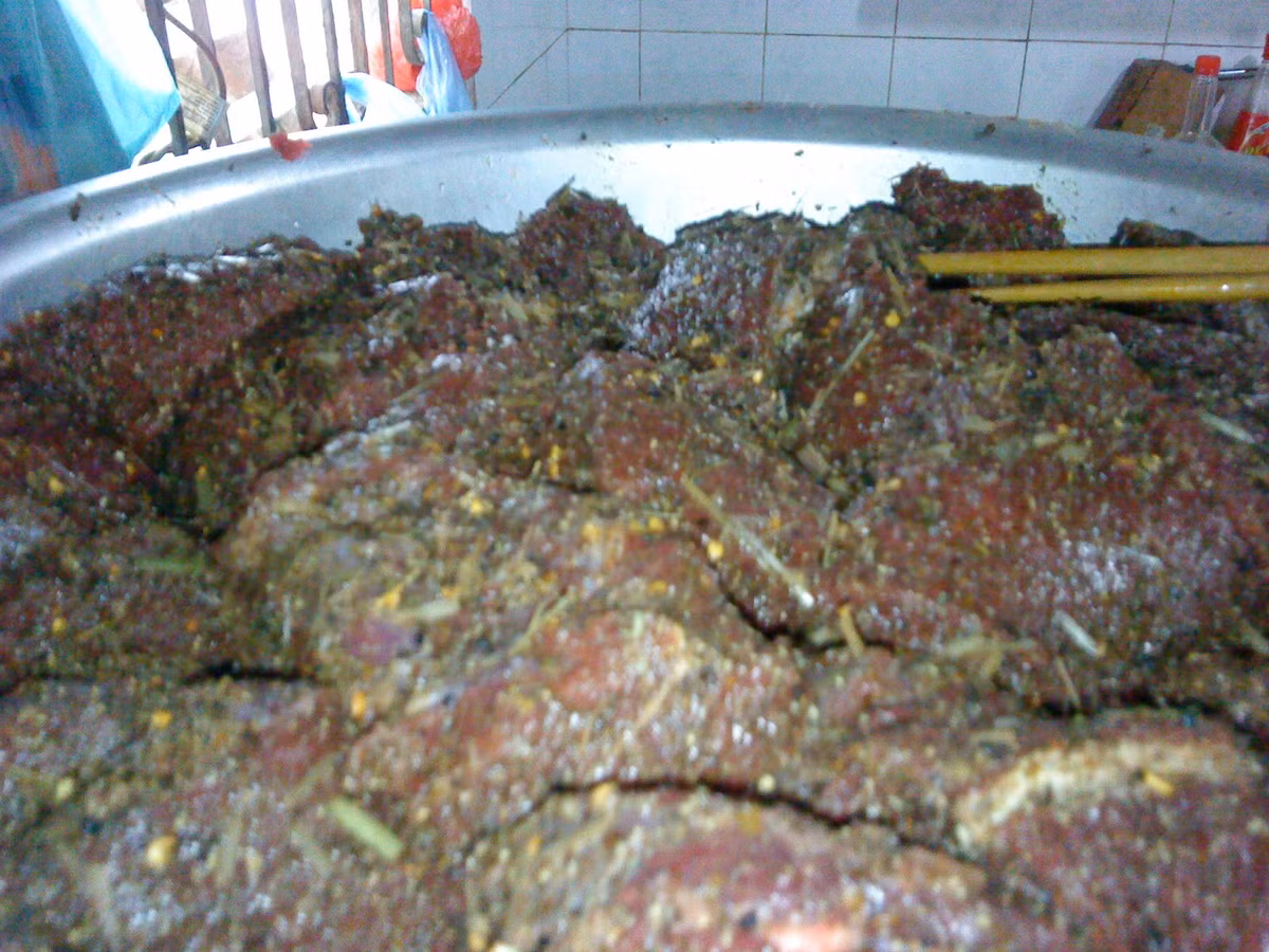 Những con trâu sau khi giết thịt sẽ được làm sạch, sau đó được lọc các thớ thịt ra thành từng miếng có chiều rộng từ 7-8 cm, chiều dài khoảng 15 cm và dày 2-3 cm. Dùng dao, búa nhỏ dần cho thịt thật mềm sau đó băm gừng, sả, tỏi, ớt, đặc biệt là mắc khén hay còn gọi là hạt tiêu rừng trộn đều và ướp trong khoảng 2-3 tiếng để thịt trâu ngấm đều các gia vị. Ảnh: Khoevadep.