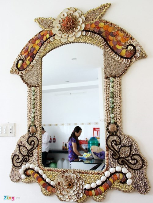 Bên cạnh 2 bộ bàn ghế được ông trưng bày tại phòng khách và phòng ăn của gia đình, còn có 1 tấm gương soi, 2 con ve và 1 con ó biển. Tất cả đều được ốp hoàn toàn bằng vỏ sò. Có nhiều vỏ sò trang trí bên trong đã đóng một lớp xà cừ quý hiếm như ngọc trai. Ảnh: Zing.