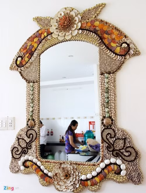 Bên cạnh 2 bộ bàn ghế được ông trưng bày tại phòng khách và phòng ăn của gia đình, còn có 1 tấm gương soi, 2 con ve và 1 con ó biển. Tất cả đều được ốp hoàn toàn bằng vỏ sò. Có nhiều vỏ sò trang trí bên trong đã đóng một lớp xà cừ quý hiếm như ngọc trai. Ảnh: Zing.