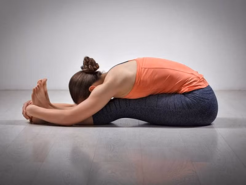 Bạn chỉ cần ngồi trên sàn, hai chân duỗi thẳng phía trước, hít sâu, duỗi toàn thân về phía trước, lõm phần lưng xuống, hai bàn tay nắm lấy ngón chân cái, trán đặt lên đầu gối. Ảnh: theducthammydangngoc.