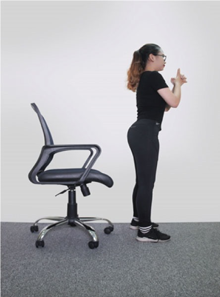 Trước tiên, bạn hãy đứng thẳng lưng ở trước ghế rồi từ từ gập người về phía ghế (lưng vẫn thẳng), ngồi xổm khi bạn tiếp xúc với ghế khoảng 10 giây rồi trở về tư thế ban đầu. Ảnh: laodong.