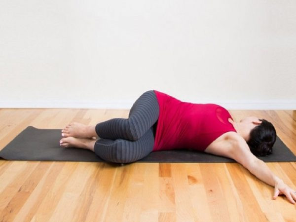 Cách thực hiện như sau: Bạn nằm ngửa, co chân và nghiêng đầu gối về một bên, giữ nguyên tư thế trong vòng 10 giây rồi làm ngược lại. Ảnh: thoaihoacotsong.