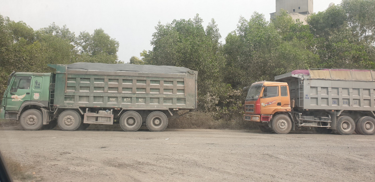 Xe tải cơi nới thành thùng, dấu hiệu chở quá tải nối đuôi nhau núp sâu trong bãi đất ven đường Hồ Chí Minh khi phát hiện có bóng dáng CSGT tỉnh Hòa Bình.