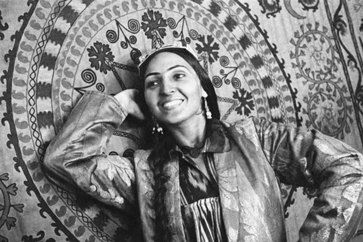 Người phụ nữ cười tươi tạo dáng chụp ảnh bên đồ thêu truyền thống của Uzbekistan. Tờ báo Xô viết Pravda Vostoka đã thuê Penson chụp ảnh cho họ.