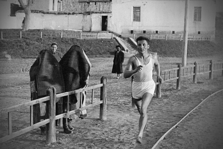 Các phụ nữ trong trang phục Hồi giáo burqa đang cổ vũ cho một vận động viên chạy.