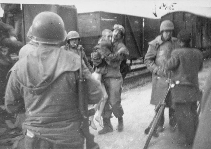 Những người lính Mỹ đưa một trong số những người còn sống khỏi "chuyến tàu tử thần" ở Dachau.