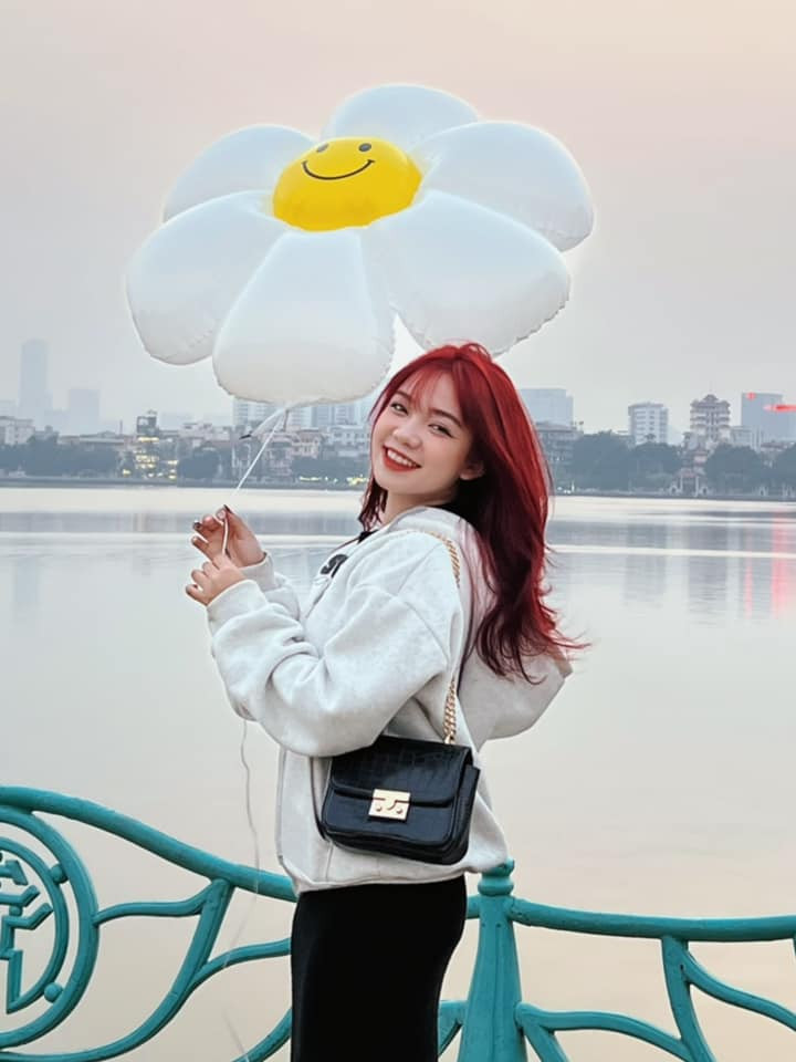 Hình ảnh giới trẻ tạo dáng bên bóng bay hoa cúc tại hồ Tây. Ảnh: Hà Phương