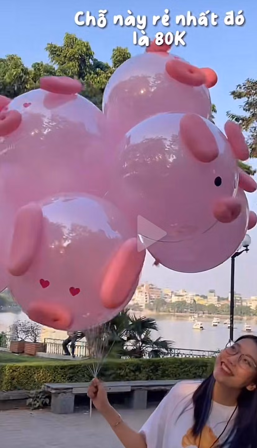 Lướt trên MXH sẽ thấy xuất hiện khá nhiều hình ảnh các cô gái, chàng trai tạo chụp ảnh check in bên bóng bay hình chú lợn hồng dễ thương, với phông nền là hồ Tây trong xanh trong tiết trời dịu nhẹ của mùa thu Hà Nội. Ảnh: Son Harry - Lang Thang Hà Nội
