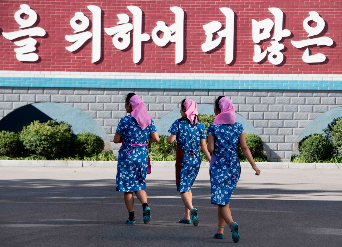 Các nữ công nhân nhanh chân tới nơi làm việc của họ tại nhà máy lụa Kim Jong Suk.