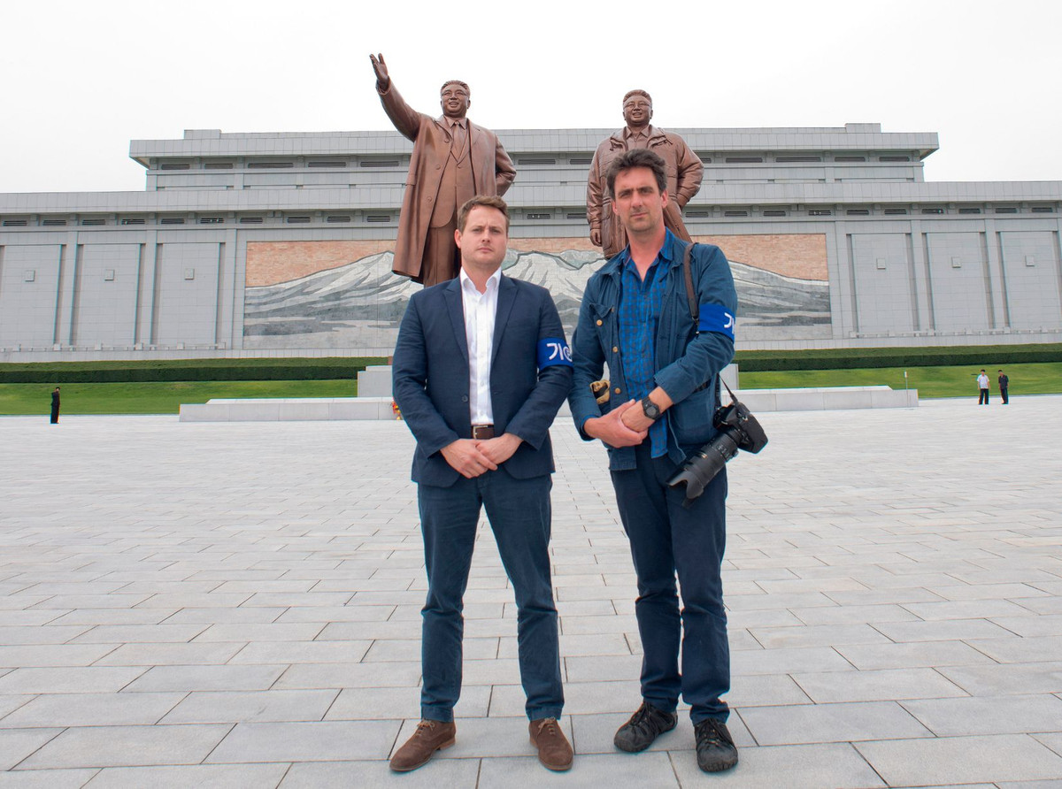 Phóng viên Russell và Rowan chụp ảnh lưu niệm trước tượng đài của nhà sáng lập Triều Tiên Kim Il-sung và cố Chủ tịch Kim Jong-il tại Bình Nhưỡng.