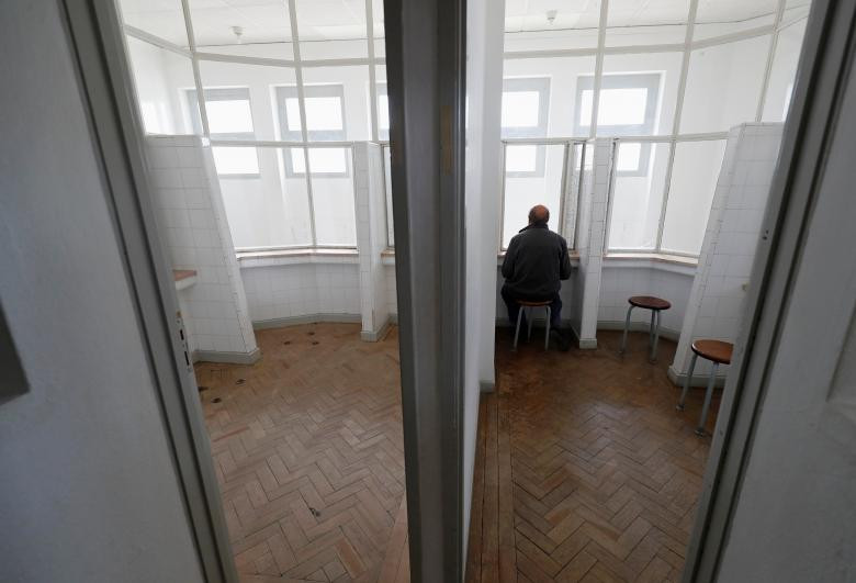 Cựu tù nhân chính trị Domingos ngồi trong căn phòng dành cho những người nhà đến thăm tù nhân.